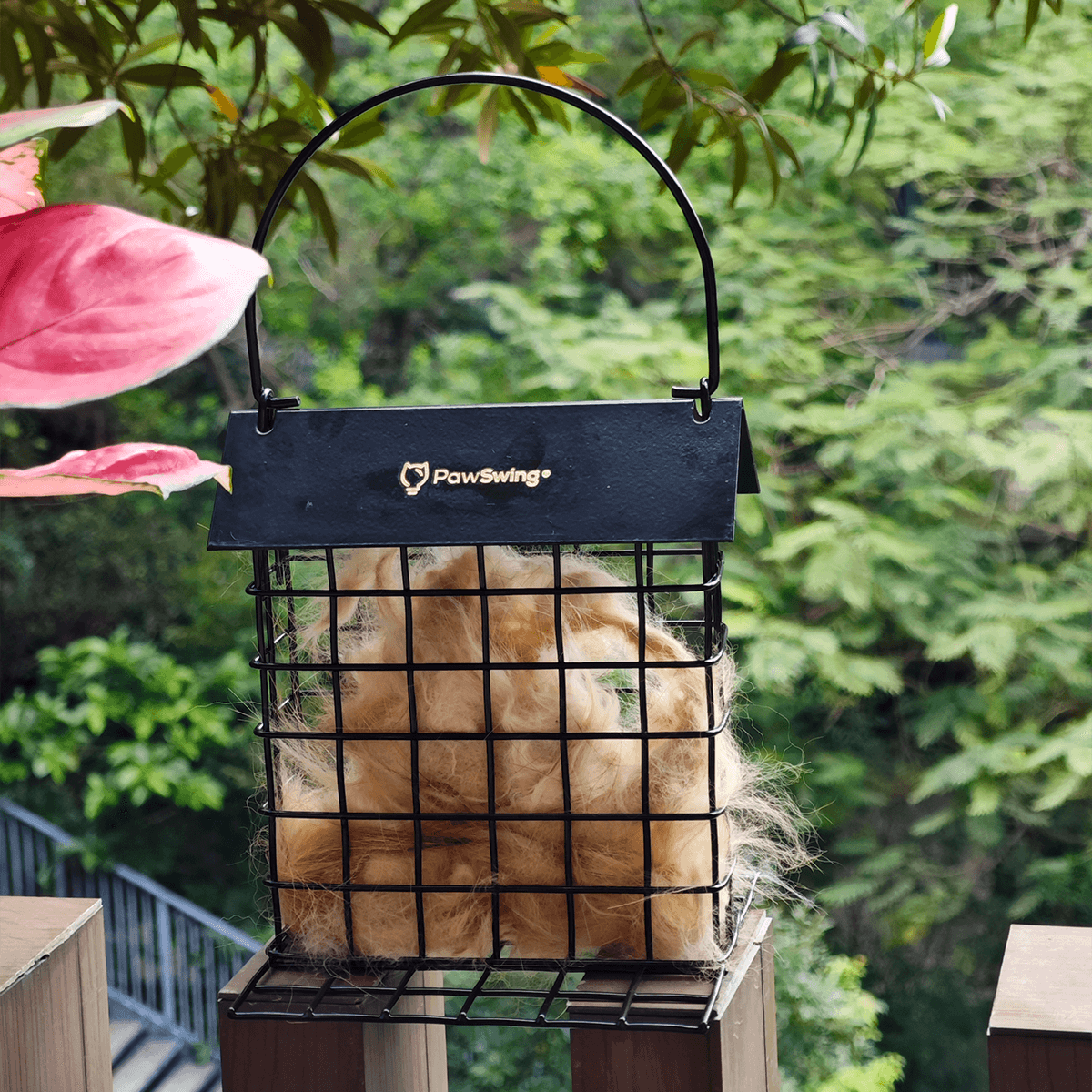 Outdoor-Szene mit der umweltfreundlichen PawSwing® Station zur Katzenhaar-Wiederverwendung im grünen Laub